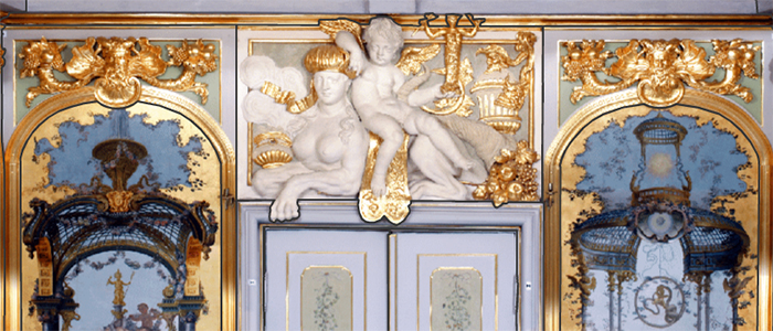 fragment dekoracyjnej ściany, motywy orientalne, w centrum fragment białych drzwi, nad nimi biała płaskorzeźba ze złoceniami